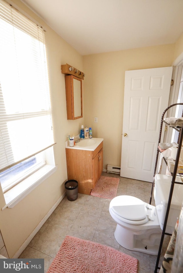 bathroom featuring baseboard heating, tile patterned floors, toilet, and vanity