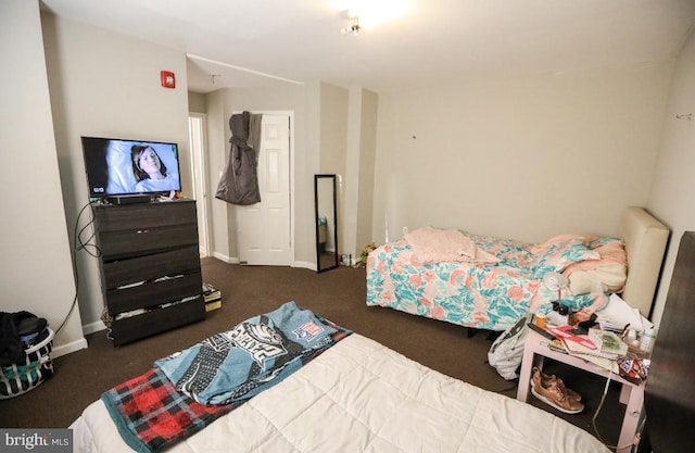bedroom featuring carpet and baseboards