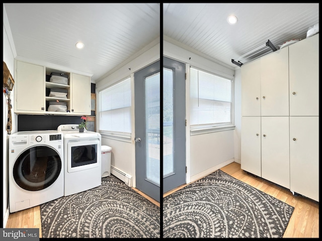 washroom featuring washer and dryer, plenty of natural light, cabinet space, and a baseboard radiator