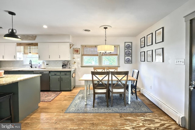 dining room featuring light wood-style floors, a baseboard radiator, baseboards, and recessed lighting