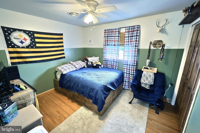 bedroom with baseboards, ceiling fan, and wood finished floors
