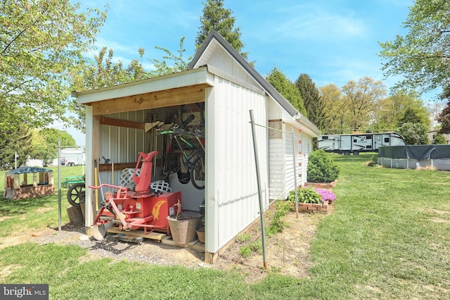 view of outdoor structure featuring a fenced in pool and an outbuilding