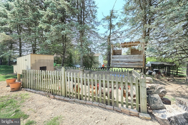 exterior space featuring fence and an outbuilding