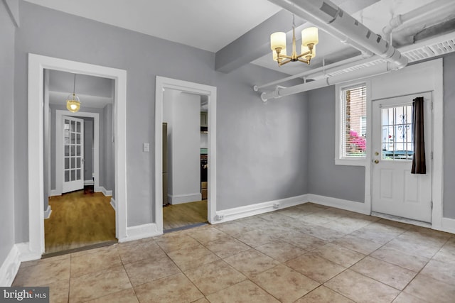 101 W 39th St Unit 101, Baltimore, MD 21210 - foyer entrance featuring light tile patterned flooring, baseboards, and an inviting chandelier