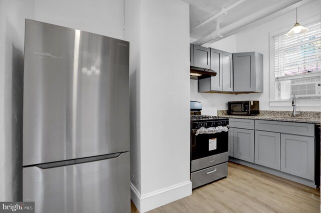 101 W 39th St Unit 101, Baltimore, MD 21210 - kitchen with light wood-type flooring, under cabinet range hood, a sink, gray cabinetry, and stainless steel appliances