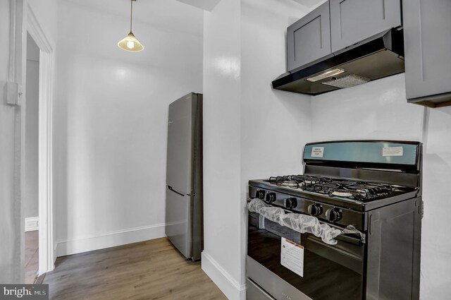 101 W 39th St Unit 101, Baltimore, MD 21210 - kitchen featuring gray cabinets, light wood-type flooring, gas stove, freestanding refrigerator, and under cabinet range hood