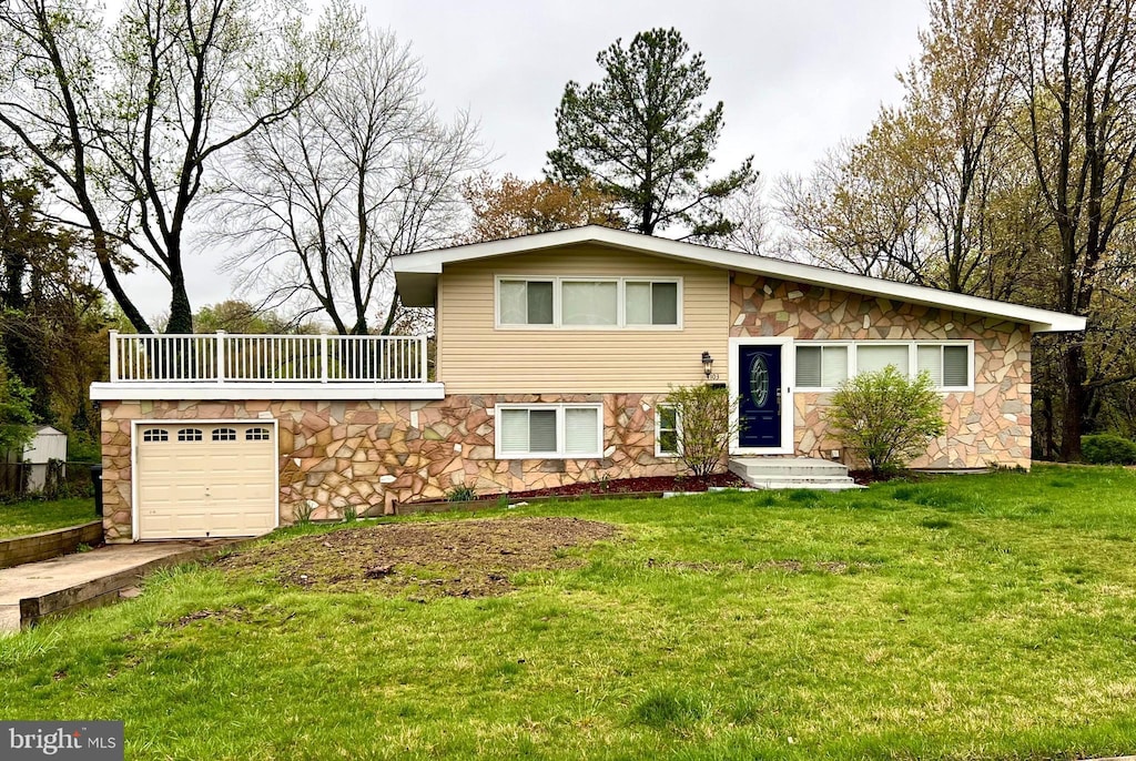 split level home with a front lawn, a garage, a balcony, stone siding, and concrete driveway