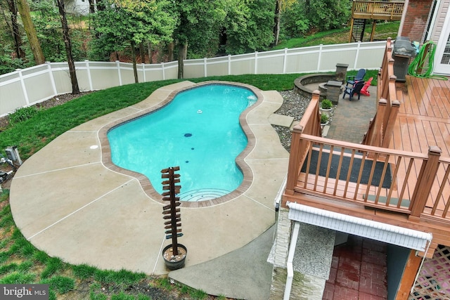 view of pool featuring a patio, a wooden deck, a fenced in pool, grilling area, and a fenced backyard