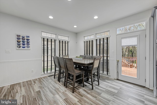 dining space with light wood-type flooring, wainscoting, and recessed lighting