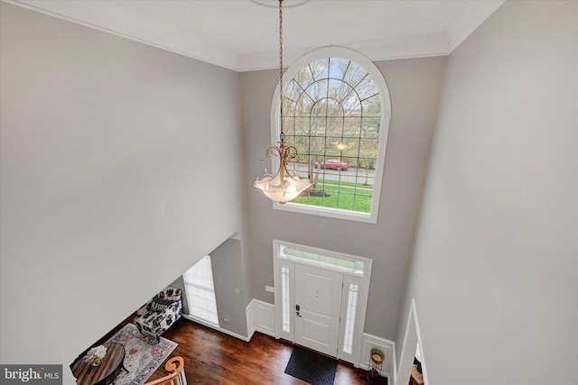 foyer with wood finished floors and ornamental molding