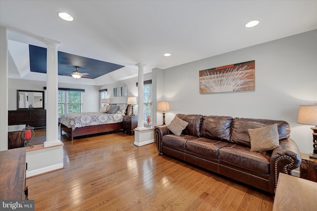 bedroom featuring ceiling fan, baseboards, wood-type flooring, recessed lighting, and decorative columns