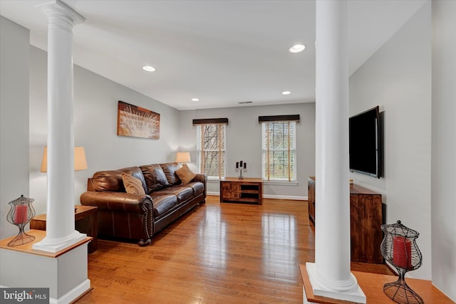 living area with ornate columns, recessed lighting, and light wood finished floors