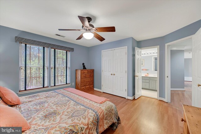 bedroom featuring baseboards, visible vents, wood finished floors, and a closet