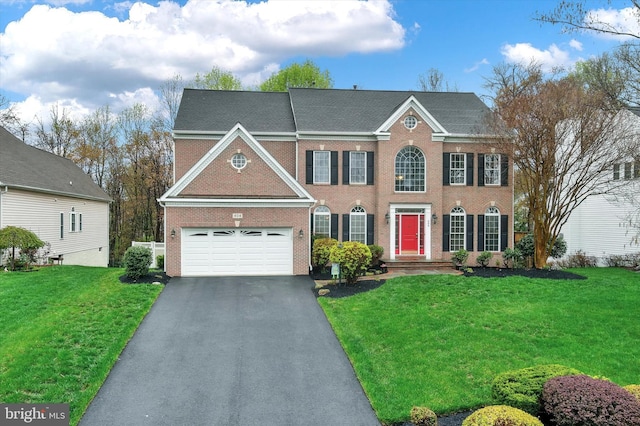 view of front of house with driveway, a front yard, brick siding, and a garage