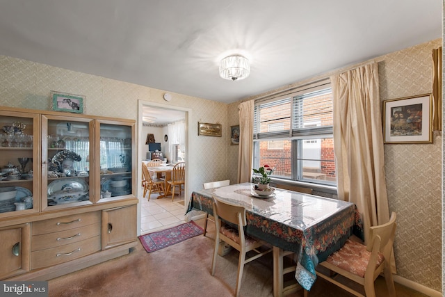 carpeted dining area featuring wallpapered walls