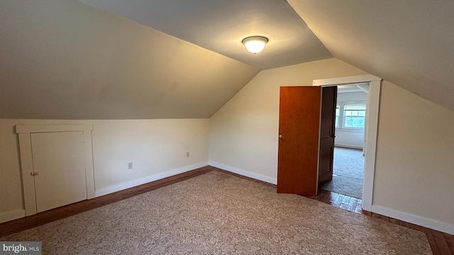 bonus room with lofted ceiling, wood finished floors, carpet, and baseboards
