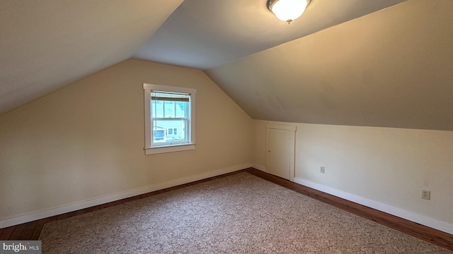 bonus room with carpet, wood finished floors, vaulted ceiling, and baseboards