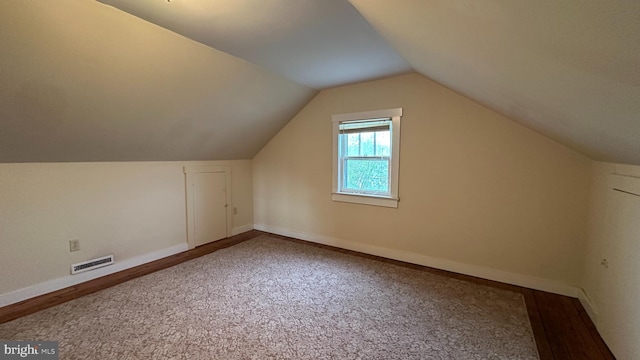 bonus room with carpet, visible vents, vaulted ceiling, and baseboards