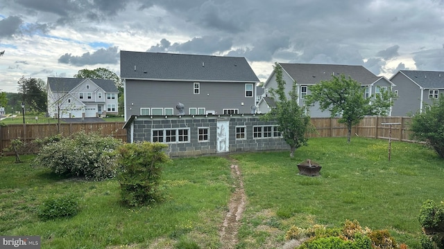 rear view of house featuring an outdoor fire pit, a fenced backyard, and a residential view
