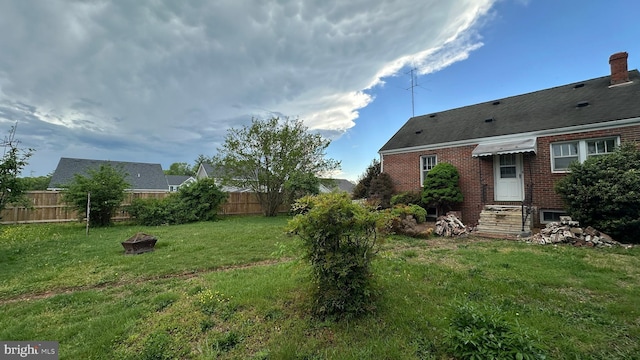 view of yard with a fire pit and fence