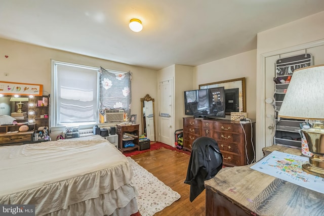 bedroom featuring wood finished floors and cooling unit