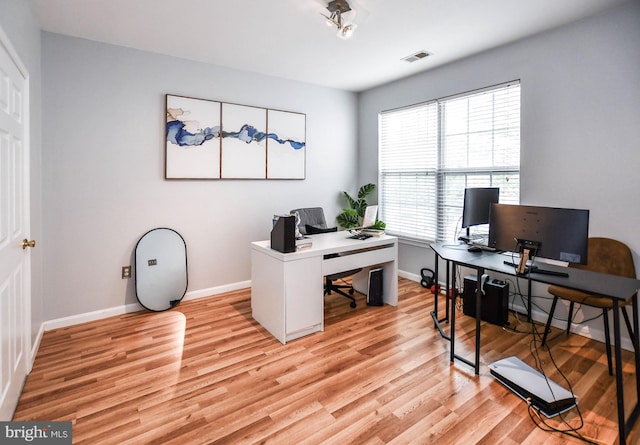home office with visible vents, light wood finished floors, and baseboards