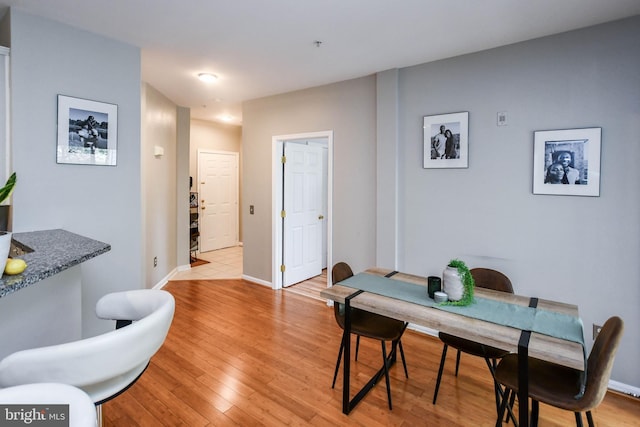 dining room featuring baseboards and light wood-style flooring