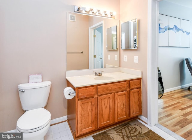 bathroom with baseboards, vanity, and toilet