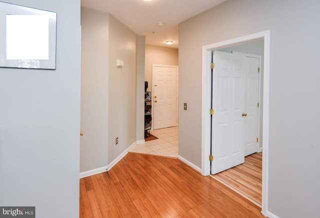 hall with baseboards and light wood-style flooring