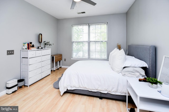 bedroom with visible vents, a ceiling fan, baseboards, and wood finished floors