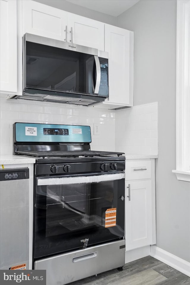 1212 Primrose Ave, Baltimore, MD 21237 - kitchen featuring white cabinets, wood finished floors, stainless steel appliances, and light countertops