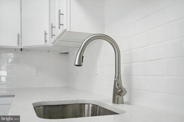 1212 Primrose Ave, Baltimore, MD 21237 - interior details with light stone countertops, white cabinetry, backsplash, and a sink