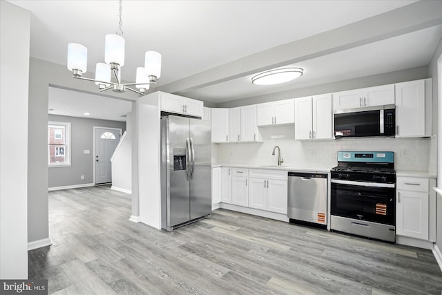 1212 Primrose Ave, Baltimore, MD 21237 - kitchen with decorative backsplash, a chandelier, stainless steel appliances, light countertops, and a sink
