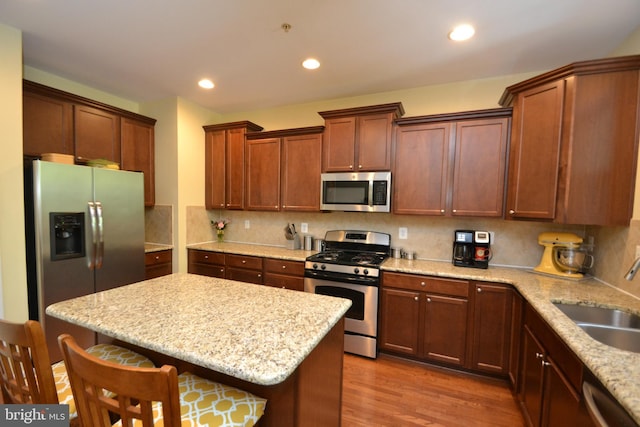 724 Hidden Oak Ln, Glen Burnie, MD 21060 - kitchen featuring a breakfast bar, a sink, a center island, stainless steel appliances, and wood finished floors