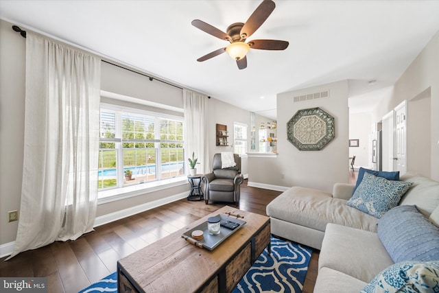 living area with baseboards, ceiling fan, wood-type flooring, and visible vents