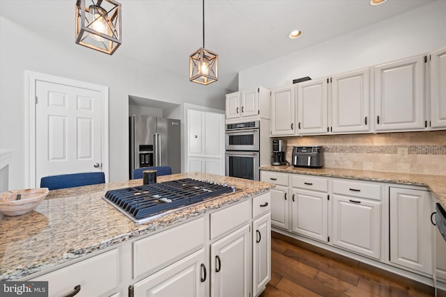 kitchen featuring decorative backsplash, white cabinets, light stone countertops, and stainless steel appliances