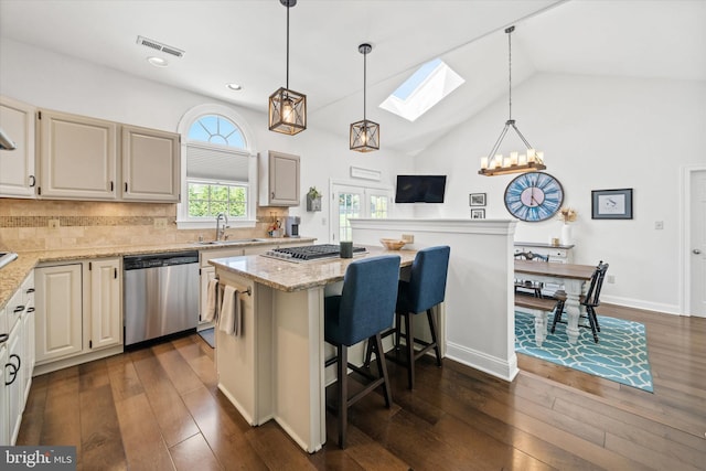 kitchen featuring a sink, a kitchen breakfast bar, stainless steel appliances, a skylight, and visible vents