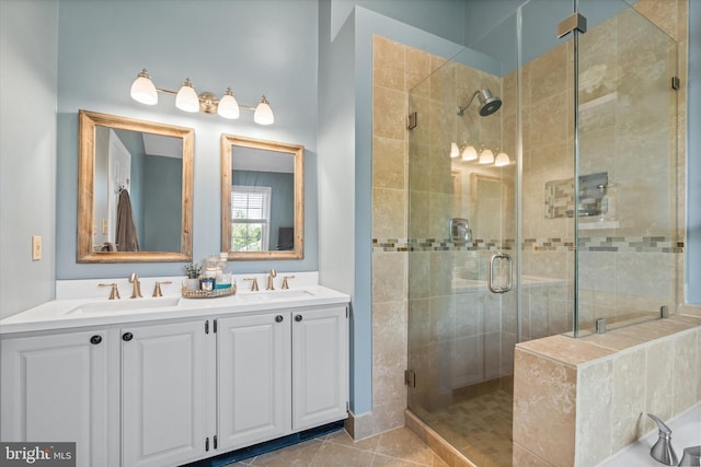 bathroom with a sink, tile patterned floors, a shower stall, and double vanity