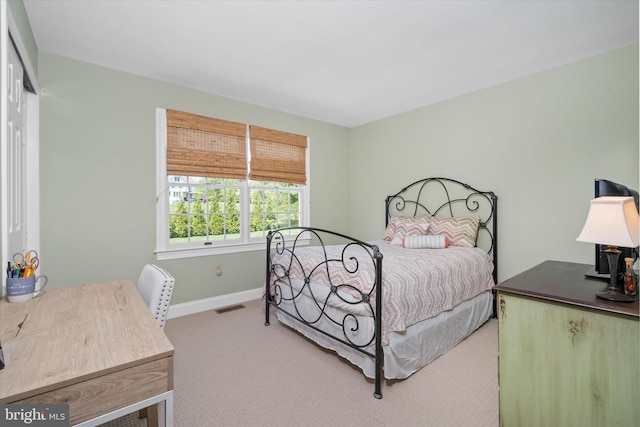 carpeted bedroom featuring baseboards, a closet, and visible vents