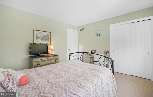 bedroom featuring light colored carpet, visible vents, and a closet