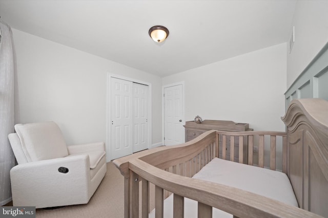 carpeted bedroom featuring baseboards and a closet