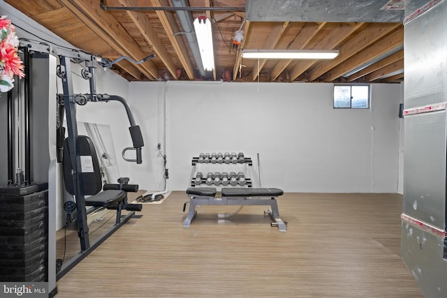 workout area featuring heating unit and wood finished floors