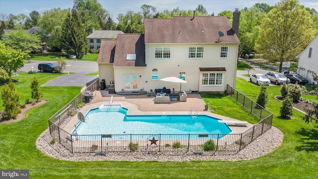 rear view of property featuring a fenced backyard, a chimney, and a yard