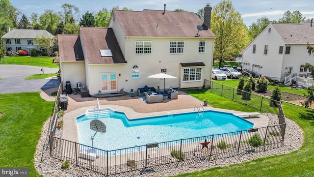 back of house with a lawn, an outdoor living space, french doors, and a chimney