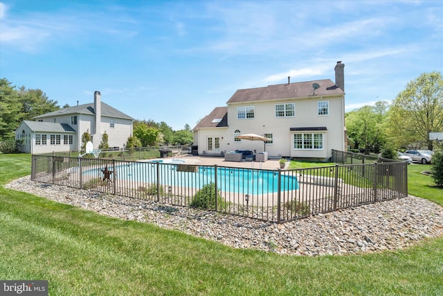 view of swimming pool featuring a fenced in pool, fence, a patio, and a lawn