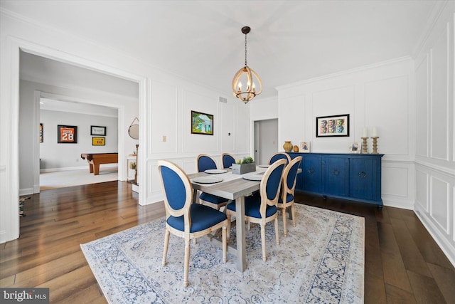 dining room with an inviting chandelier, crown molding, visible vents, a decorative wall, and dark wood-type flooring