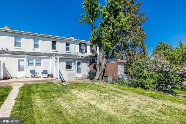 back of property featuring a lawn, fence, a patio, and stucco siding