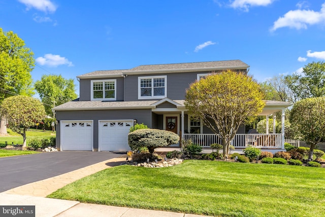 traditional-style home with a porch, an attached garage, a front yard, and aphalt driveway