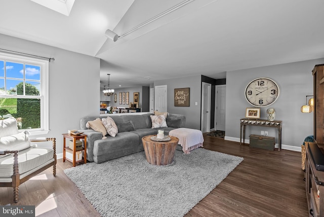 living area with an inviting chandelier, dark wood-style flooring, and baseboards