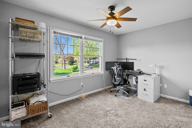 carpeted office space with baseboards and ceiling fan